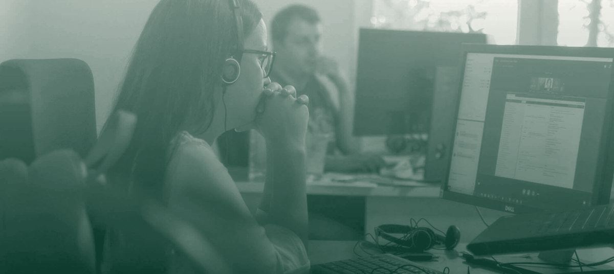 A developer with a headset focused at her desk