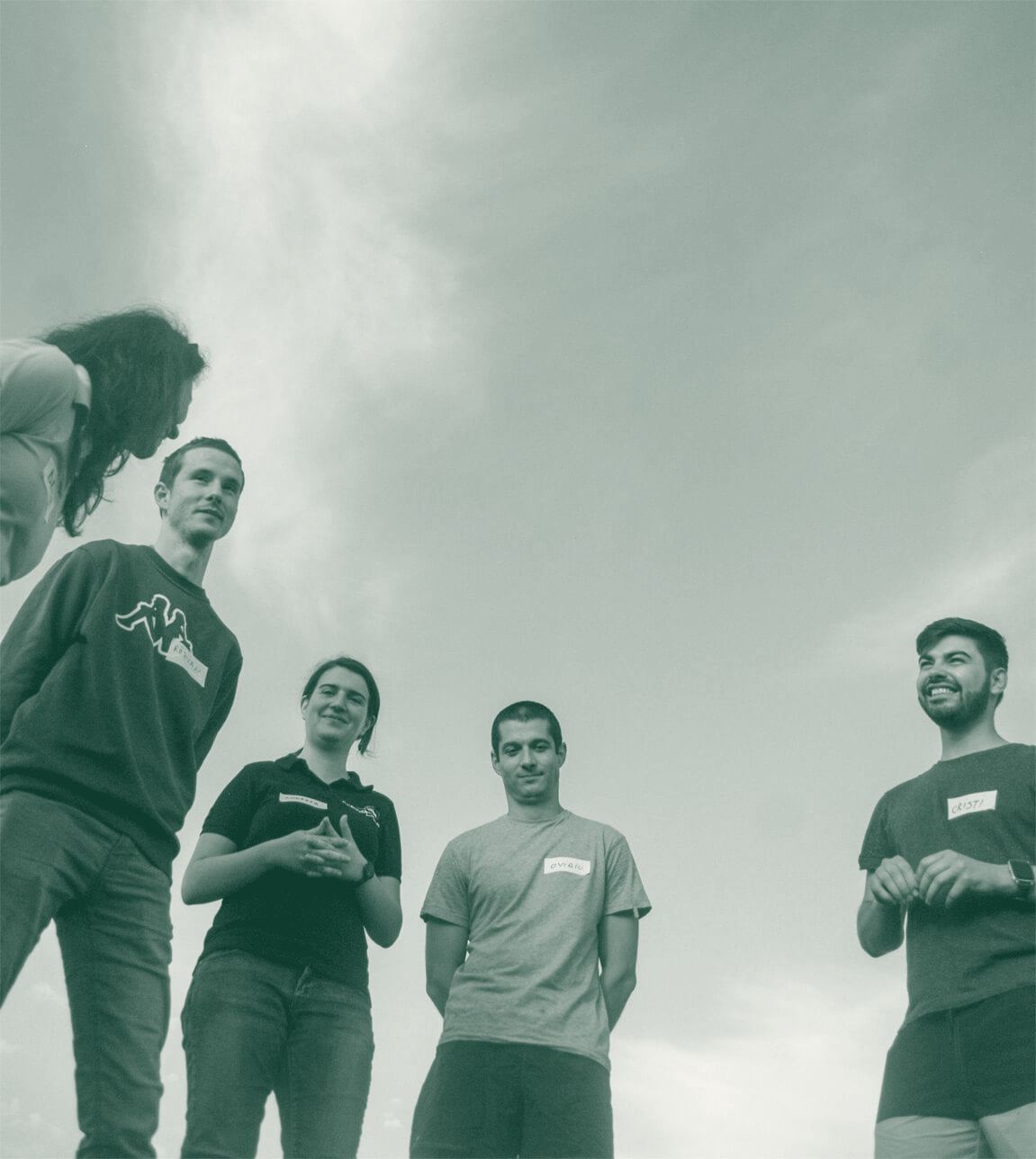 Team members talking outdoors under an open sky
